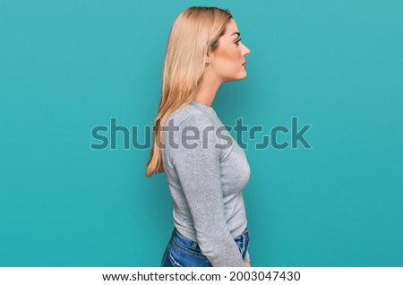 Young caucasian woman wearing casual clothes looking to side, relax profile pose with natural face with confident smile. 