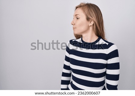 Young caucasian woman wearing casual navy sweater looking to side, relax profile pose with natural face with confident smile. 