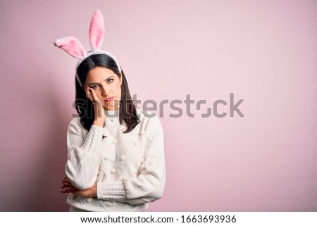 Young caucasian woman wearing cute easter rabbit ears over pink isolated background thinking looking tired and bored with depression problems with crossed arms.