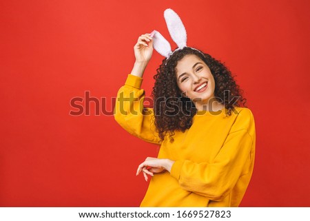 Young caucasian woman wearing cute easter rabbit ears over red isolated background while smiling confident and happy.