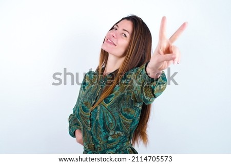 Young caucasian woman wearing floral dress over white background directs fingers at camera selects someone. I recommend you. Best choice