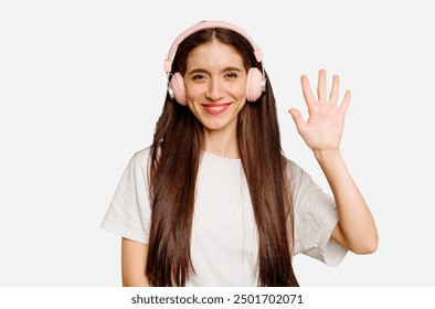 Young caucasian woman wearing headphones isolated smiling cheerful showing number five with fingers.