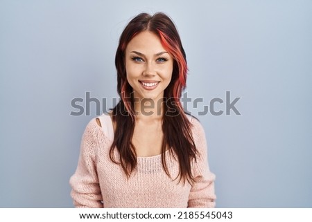 Young caucasian woman wearing pink sweater over isolated background with a happy and cool smile on face. lucky person. 