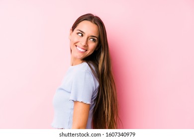 Young Caucasian Woman Wearing A Ski Clothes Isolated Looks Aside Smiling, Cheerful And Pleasant.