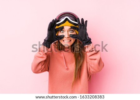 Young caucasian woman wearing a ski clothes isolated keeping eyes opened to find a success opportunity.