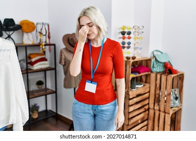 Young caucasian woman working as manager at retail boutique tired rubbing nose and eyes feeling fatigue and headache. stress and frustration concept. 