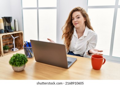 Young Caucasian Woman Working At The Office Using Computer Laptop Clueless And Confused With Open Arms, No Idea Concept. 