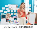 Young caucasian woman working as teacher at kindergarten disgusted expression, displeased and fearful doing disgust face because aversion reaction. with hands raised 