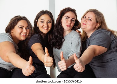Young caucasian women in casual clothes having fun together. Friends sitting near by window and laughting, spending time together. Bodypositive, nutrition, feminism, loving themself, beauty concept.