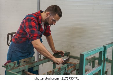 Young caucasian worker in repair shop cleaning old frame with wire brush - Powered by Shutterstock