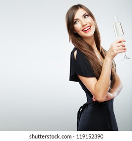 Young celebrating woman black dress . Beautiful model portrait isolated over studio background hold wine glass.