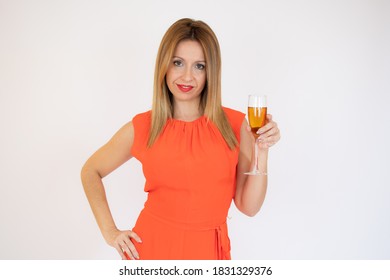 Young celebrating woman red dress. Beautiful model portrait isolated over studio background hold wine glass.