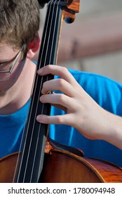 A young cellist fingers the strings of the instrument during a concert.