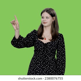 Young charming woman makes finger touching virtual display on green background, Chroma key - Powered by Shutterstock