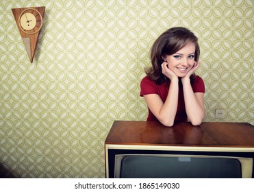 Young Charming Woman Staing At Room With Vintage Wallpaper And Retro TV Set, Retro Stylization 60-70s, Image Toned. 