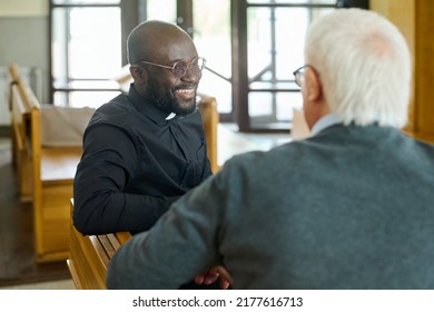 Young cheerful African American pastor of evangelical church consulting aged grey haired male parishioner after sermon - Shutterstock ID 2177616713