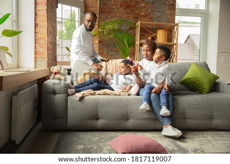 Young and cheerful african family during quarantine, spending time together at home. Concept of quarantine lifestyle, togetherness, home comfort.