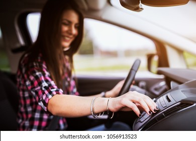 Young Cheerful Beautiful Girl Is Adjusting A Volume Of Her Stereo In The Car She Is Driving.