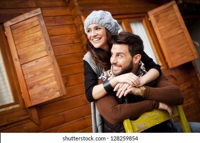 Young Cheerful Couple In A Cabin In Romantic Scape In Winter