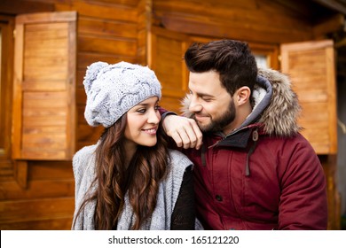 Young Cheerful Couple In A Cabin In Romantic Scape In Winter