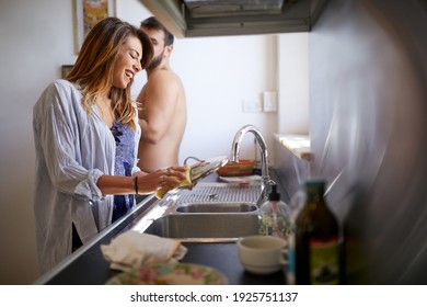 A young cheerful couple chatting in a relaxed atmosphere in the kitchen on a beautiful morning. Relationship, love, kitchen, together
