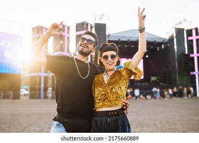 Young and cheerful couple at music festival. Happy friends drinking beer and having fun at Beach party together. Summer holiday, vacation concept. - Powered by Shutterstock