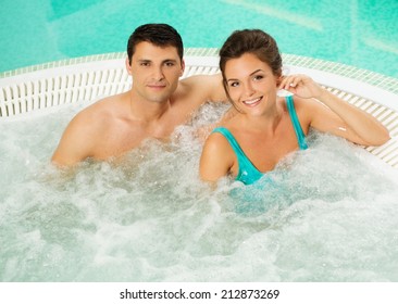 Young cheerful couple relaxing in a jacuzzi
