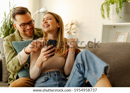 Similar – Image, Stock Photo Cheerful couple spending time together in living room