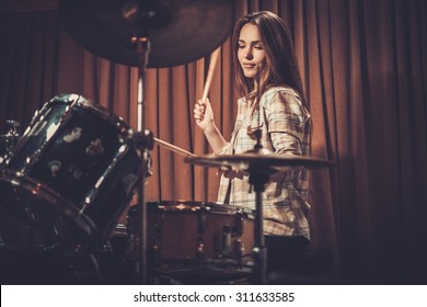 Young cheerful girl behind drums on a rehearsal  - Powered by Shutterstock