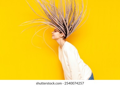 young cheerful girl with gray dreadlocks waves her head and hair flies on a yellow isolated background, a woman with an unusual hairstyle and pigtails dances and moves - Powered by Shutterstock