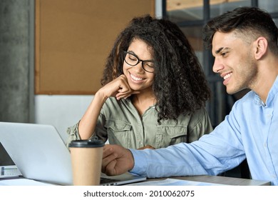 Young cheerful happy smiling female African American and male Indian coworkers discussing project strategy. Diverse startup students girl and guy talking working in modern office using laptop. - Shutterstock ID 2010062075