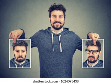 Young cheerful hipster holding photos with different emotions having problems with mood change. 
