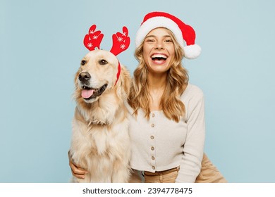 Young cheerful owner woman wear casual clothes Santa hat hug cuddle embrace best friend pet retriever dog isolated on plain pastel light blue background studio. New Year Christmas celebration concept - Powered by Shutterstock