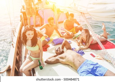 Young Cheerful People Having Fun In Boat Party With Music And Beer At Sunset - Happy Friends Enjoying Summer Vacation - Friendship And Happiness Concept - Warm Filter With Main Focus On Black Man