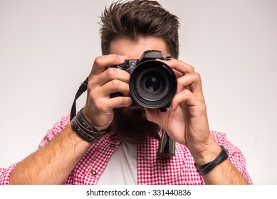 Young cheerful photographer with beard, while working in studio - Powered by Shutterstock