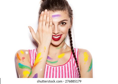 Young cheerful soiled in paint girl having fun. Smiling Woman with bright makeup and hairstyle with pigtails. White background not isolated