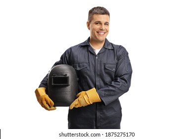 Young cheerful welder in a uniform holding a protective helmet isolated on white background