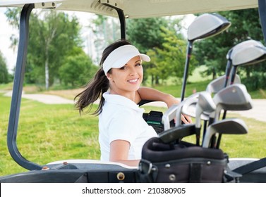 Young cheerful woman driving golf cart 