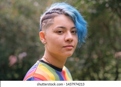 Young cheerful woman with expression of sadness and blue short hair.