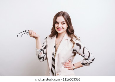 Young cheerful woman holding eyeglasses and loking confident at camera