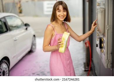 Young Cheerful Woman In Pink Dress Pushing Button On Wash Machine Choosing The Washing Mode At Car Self-service