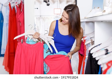 Young Cheerful Woman Shopping In Clothing Boutique