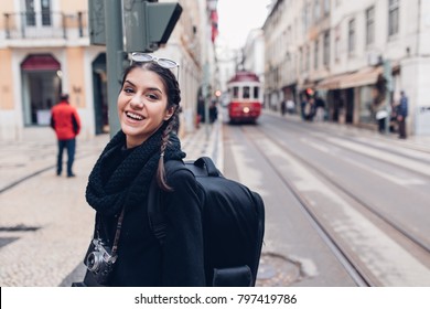Junge, fröhliche Frau, die die Straße von Lissabon entlang geht.Erstaunlicher Tourist, der Europa während der Nebensaison im Winter besucht.Student in Portugal, Europa auf einer Frühjahrsbremse, die Großstädte erforscht.Positive Frau