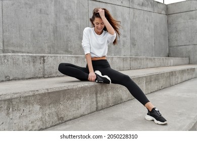 Young Cheerful Woman Wear Sweat Suit And Sitting Outdoor