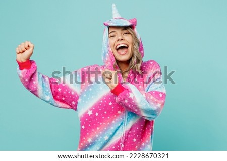 Young cheerful ywoman 20s she wear domestic costume with hoody and animals ears gesticulating hands dance on pajama party isolated on plain pastel light blue cyan background. People lifestyle concept