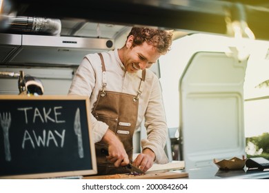 Young Chef Cooking Inside Vegan Food Truck Restaurant - Focus On Face