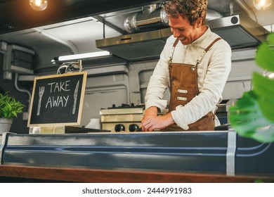 Young chef man working inside food truck preparing dinner - Summer meal concept - Focus on face - Powered by Shutterstock