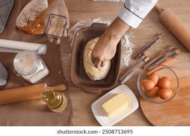 Young chef sprinkling raw bread with sesame seeds in bakery - Powered by Shutterstock