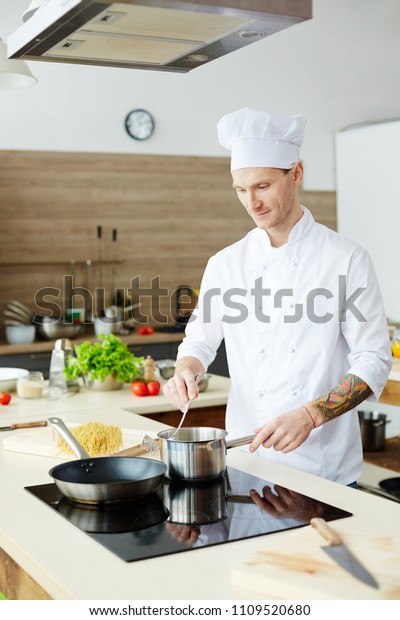 Young Chef Standing By Electric Stove Stock Photo Edit Now