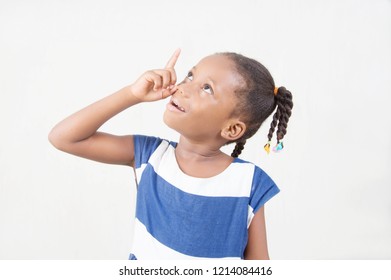 Young Child Amazed And Surprised By Looking Up And Pointing With The Fingers And The Arm Raised Up.